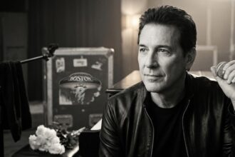 Tommy DeCarlo performing live on stage with the rock band Boston.